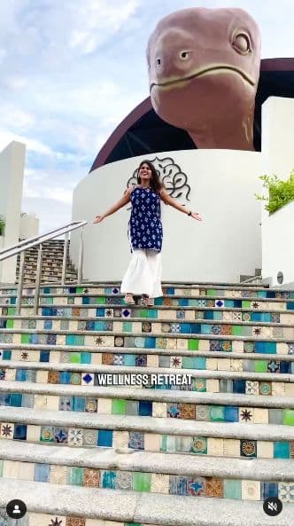 Influencer content: a guest on the tiled steps in front of the turtle-roofed building