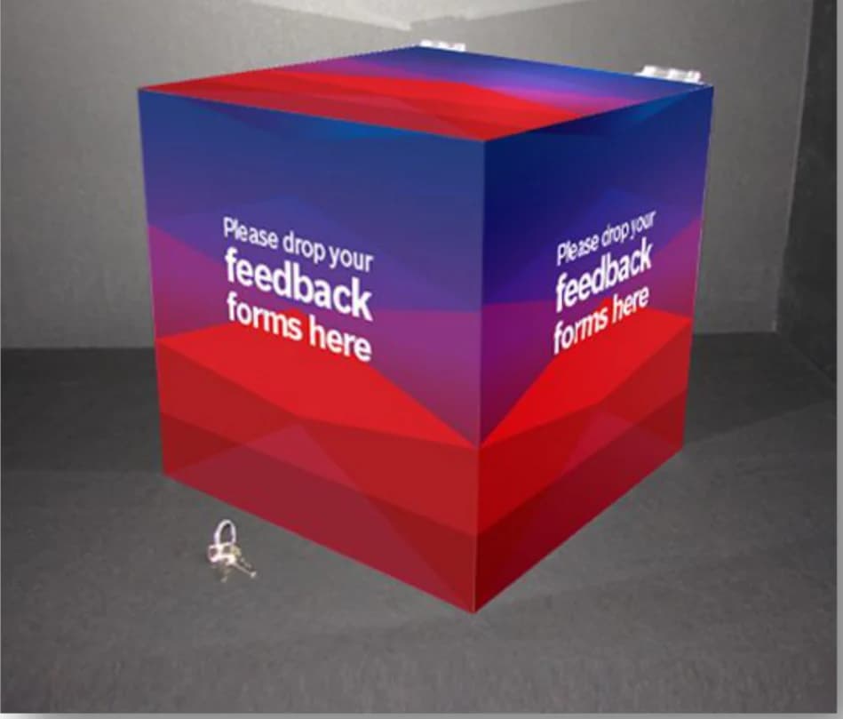 A feedback drop cube in the Bosch colour gradient: “Please drop your feedback forms here”