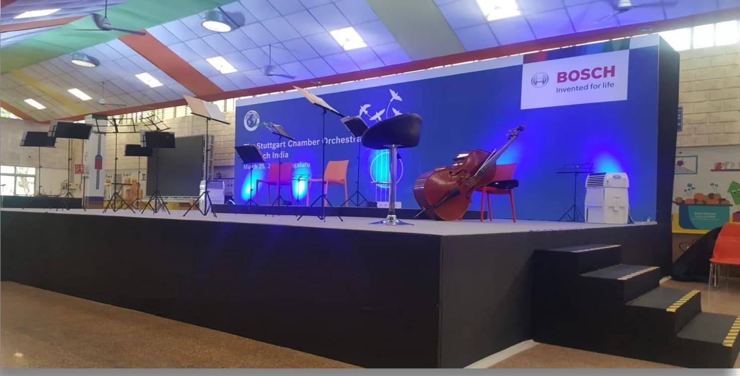 The concert stage lit in blue, with a Bosch backdrop and instruments ready